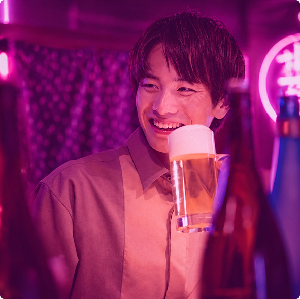 店内でビールを手に笑顔を見せる男性